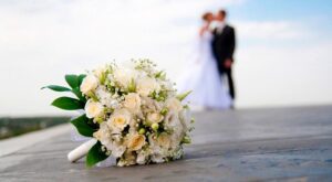 свадебный букет цветов на фоне молодоженов